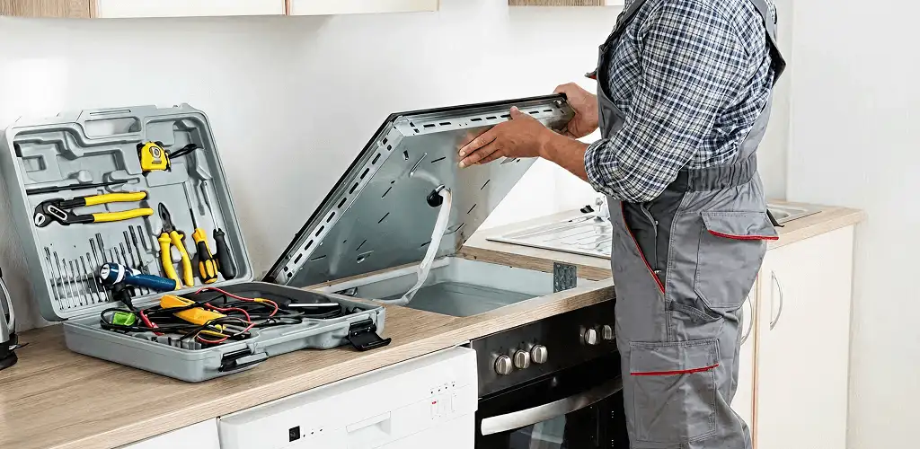Handyman repairing a cooktop and checking wiring connections in Norfolk, VA