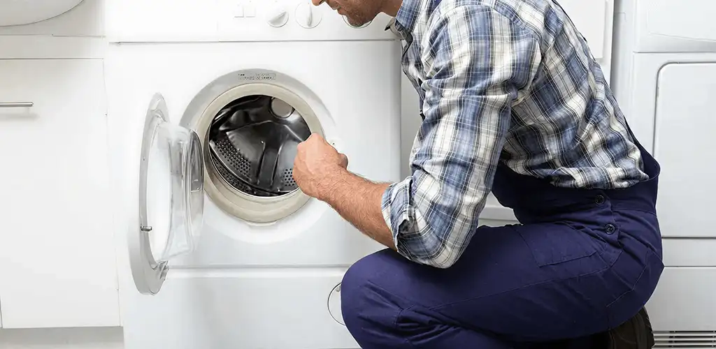 Handyman inspecting a dryer drum and internal parts for repair in Norfolk, VA