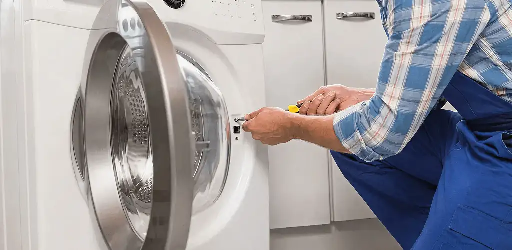 Handyman repairing a clothes dryer and checking electrical connections in Norfolk, VA