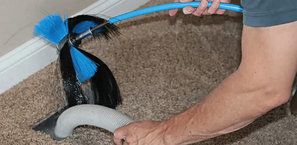 Dryer vent cleaning technician brushing lint from a vent line in Norfolk, VA
