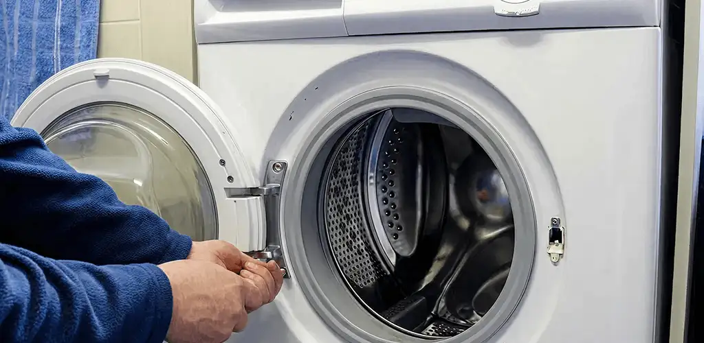Washing machine repair handyman checking a front-load washer door and latch in Norfolk, VA