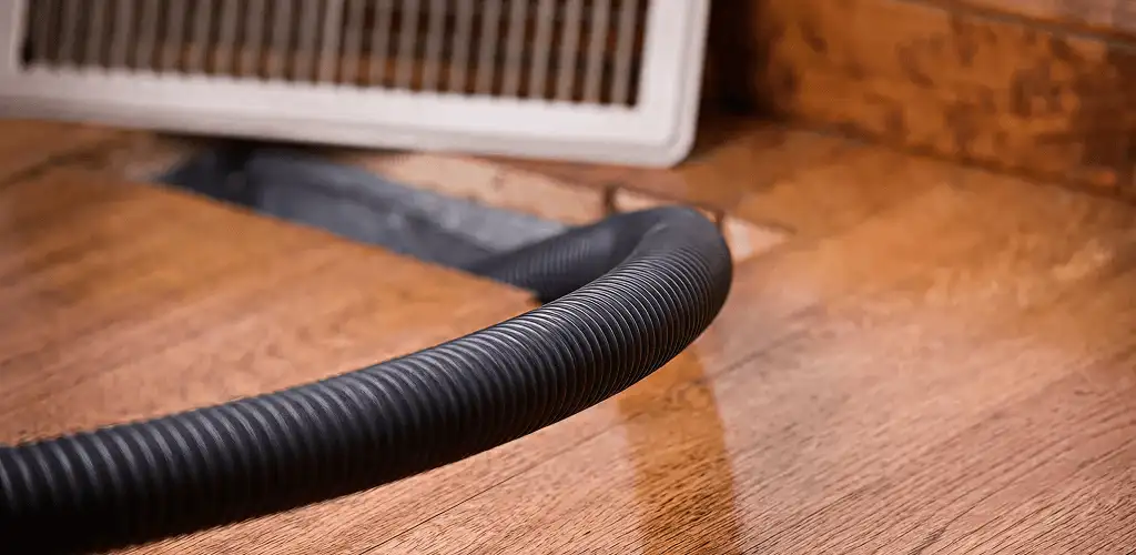 Air duct cleaning hose inserted into a floor vent for ductwork cleaning in Norfolk, VA