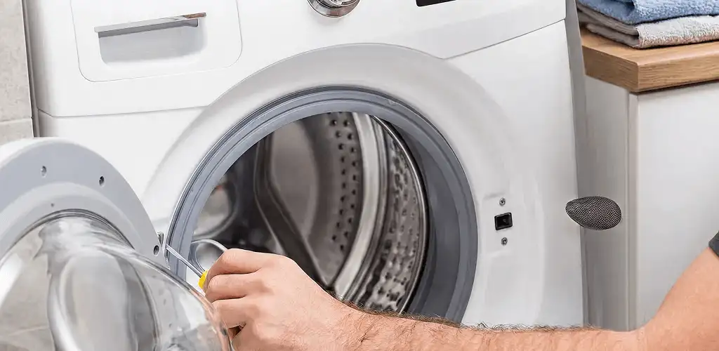 Handyman repairing a front-load washing machine and inspecting the drum in Norfolk, VA