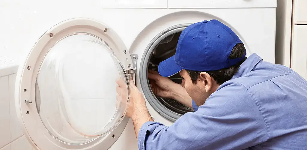 Washing machine repair handyman inspecting a front-load washer drum in Norfolk, VA