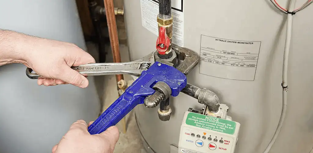 Water heater repair technician tightening the shutoff valve and supply line in Norfolk, VA